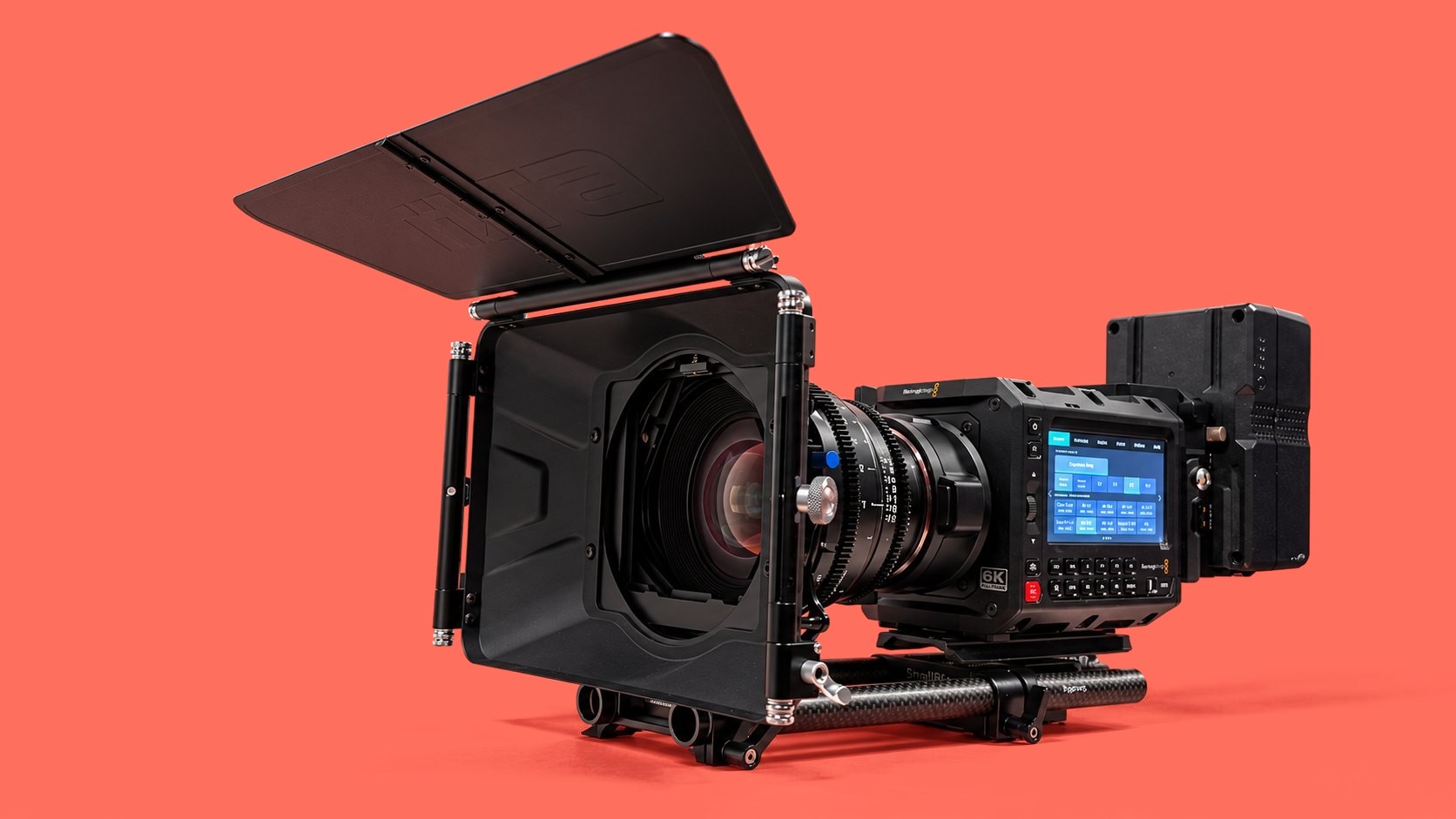 Cinema camera rig with matte box on a coral background